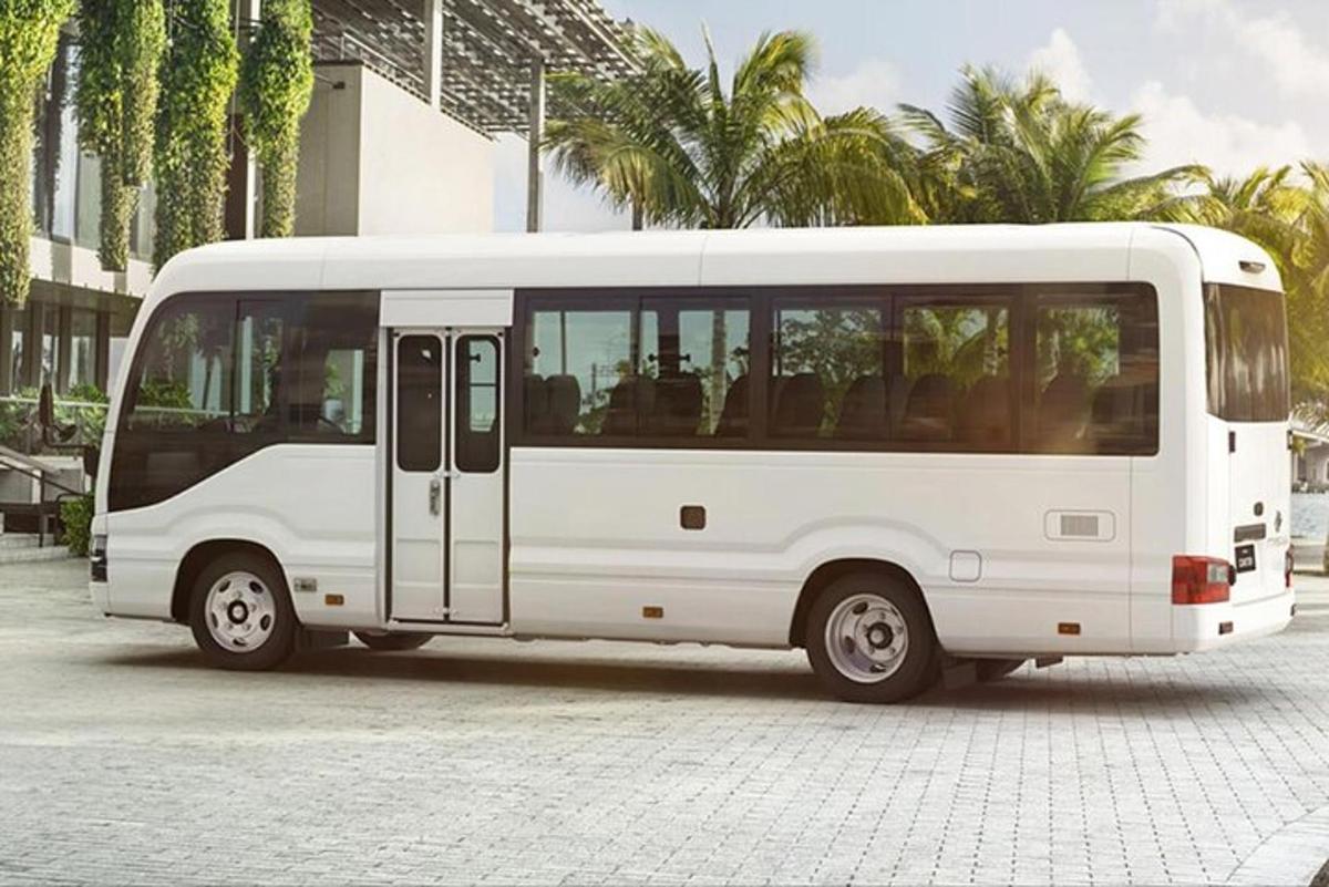 egy fehér busz parkolt egy pálmafákkal teli parkolóban
