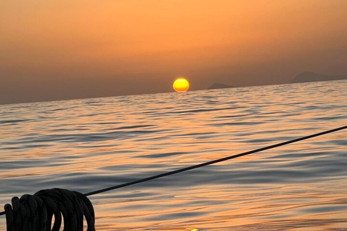 夕阳下，一个人在水中拿着鱼竿