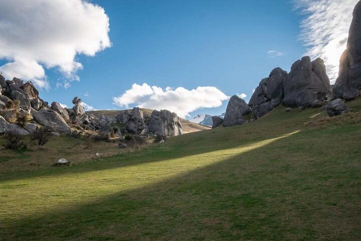 a person standing on top of a hill with rocks