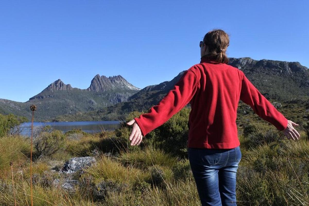 a woman standing on a hill with her arms outstretched