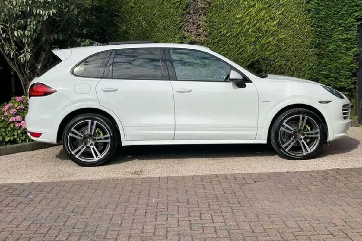 білий автомобіль, припаркований на цегляній дорозі