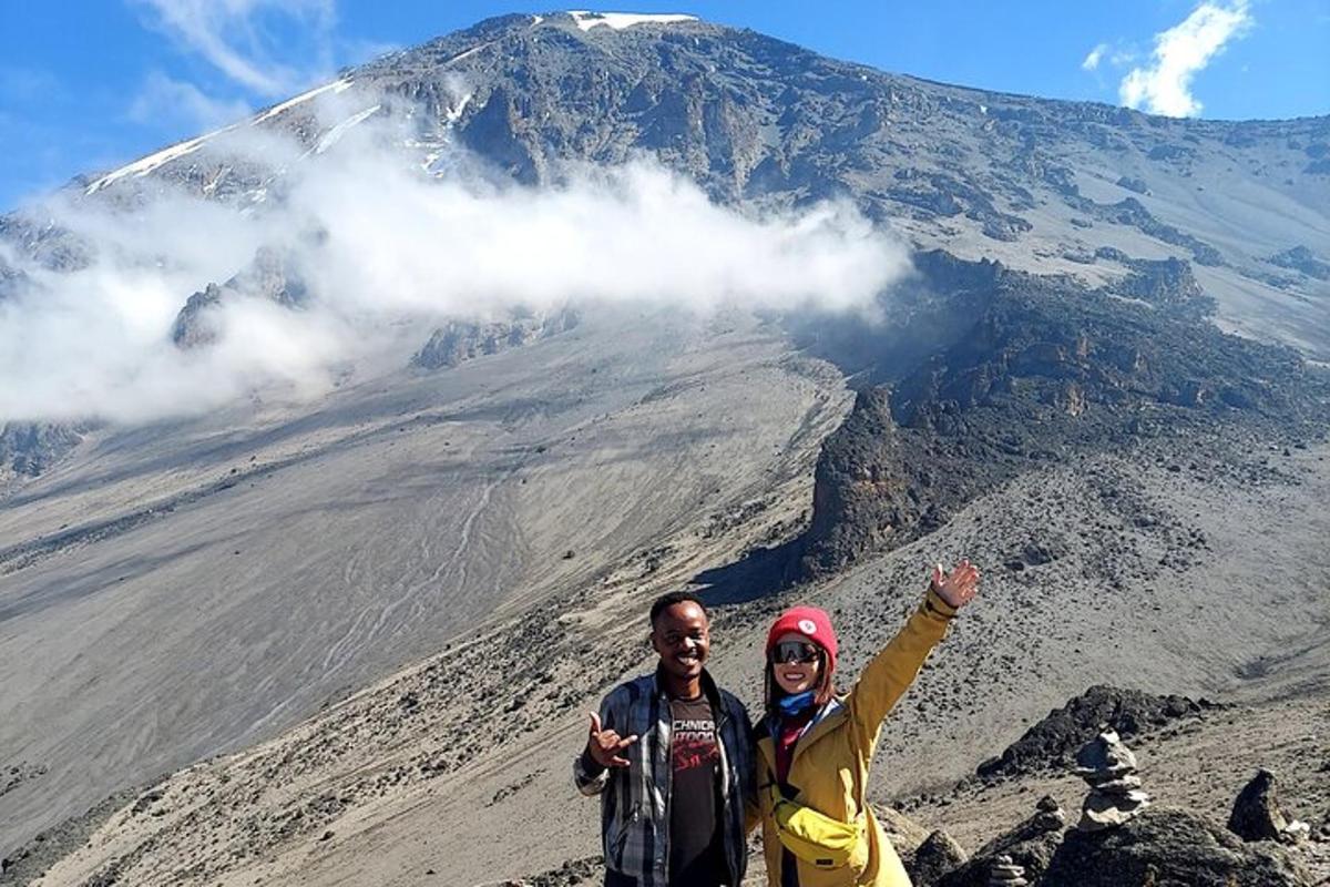 seorang lelaki dan perempuan berdiri di hadapan sebuah gunung