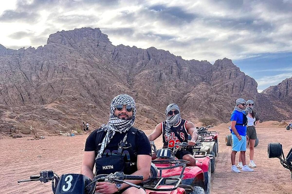 a group of people riding atvs in the desert