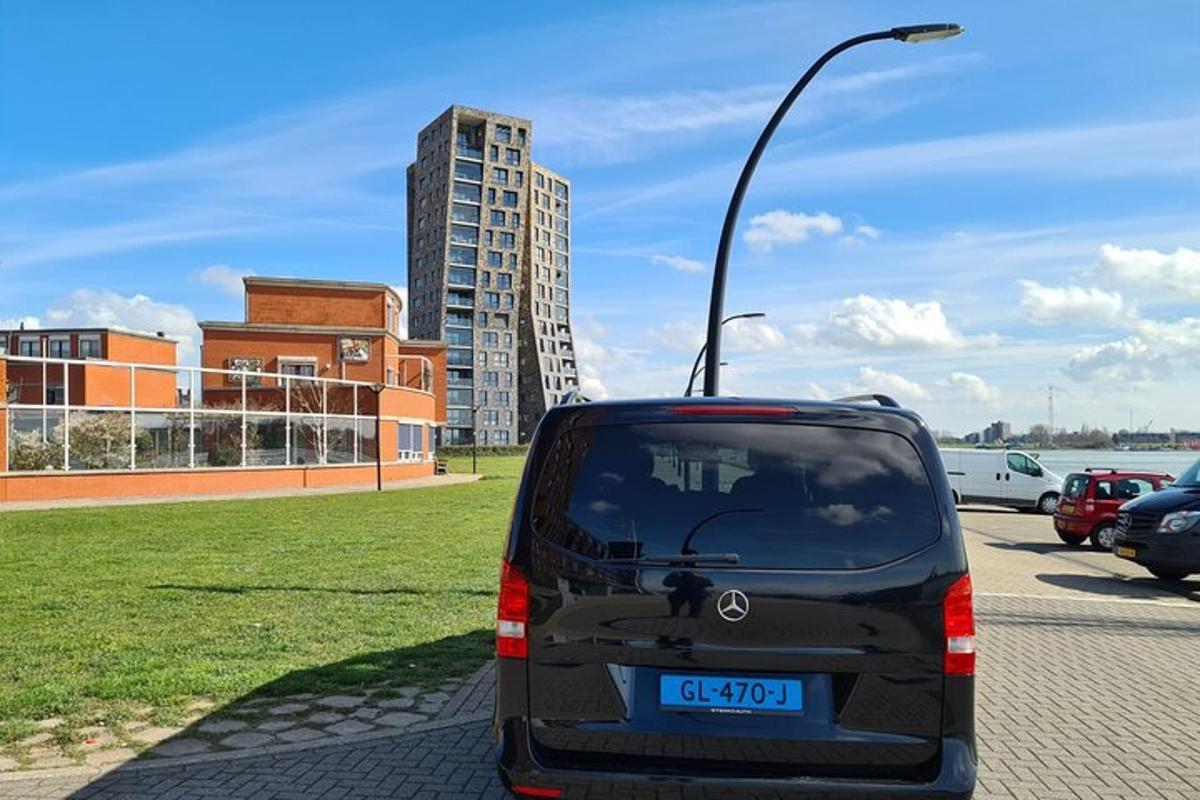 musta pakettiauto pysäköitynä kadulle, jossa on katuvalo