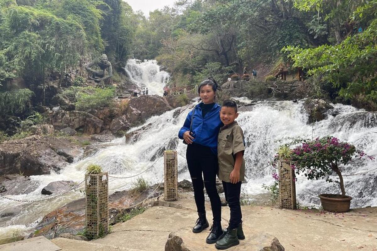 una dona i un nen drets davant d'una cascada