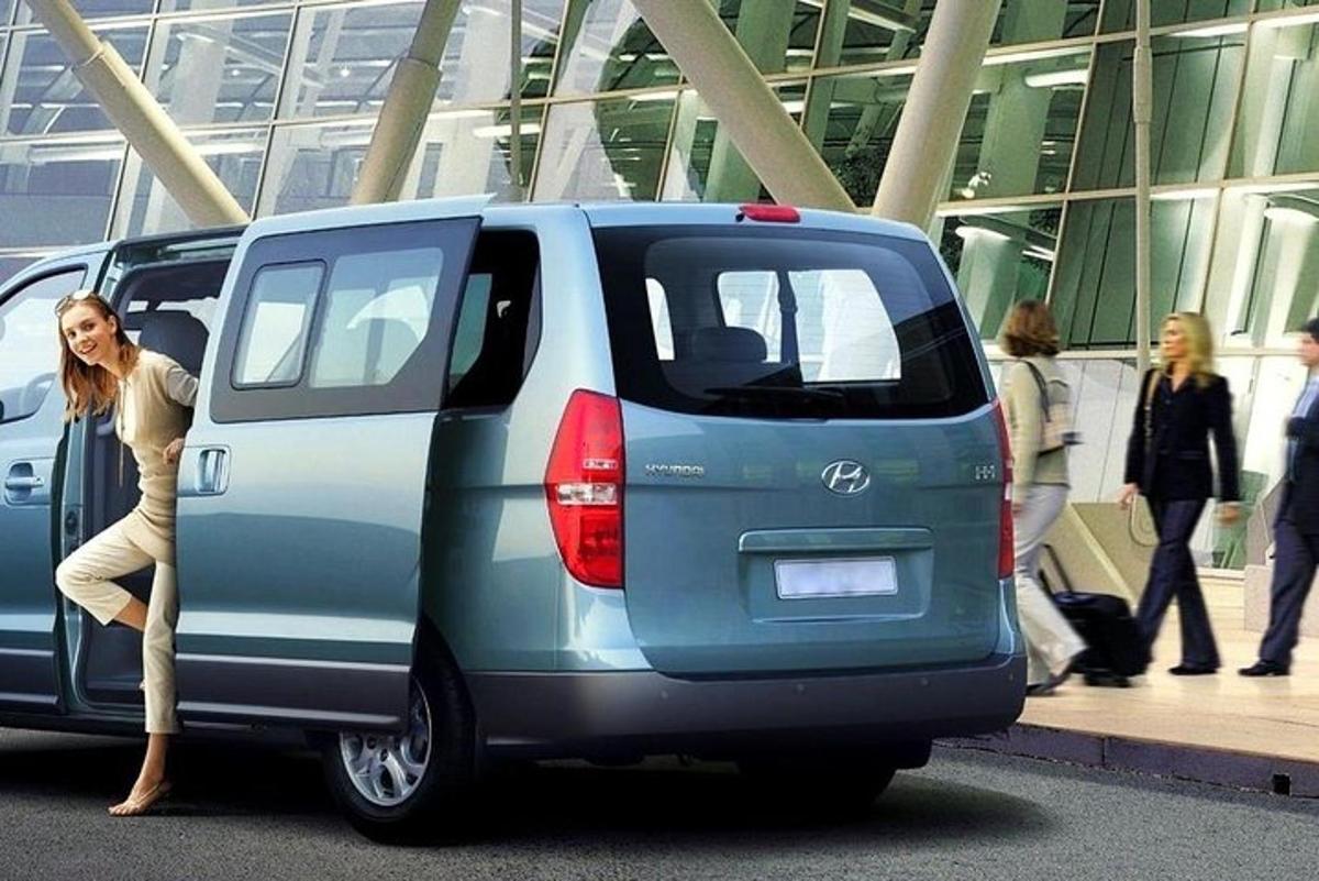 Una mujer está parada en la parte trasera de una minivan.