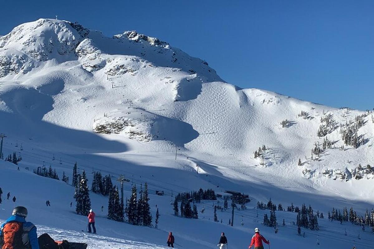 um grupo de pessoas esquiando montanha abaixo coberta de neve