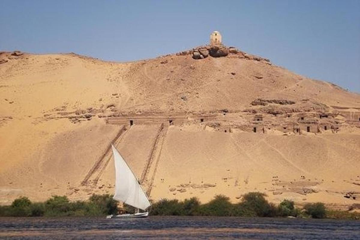una barca a vela sull'acqua di fronte a una montagna
