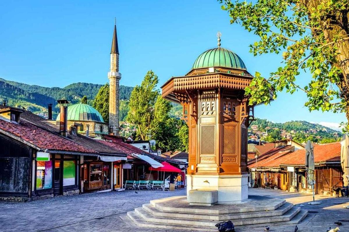 uma torre do relógio no meio de uma cidade com uma mesquita