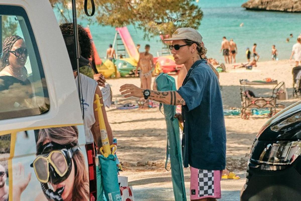 un home dret al costat d'un camió a la platja