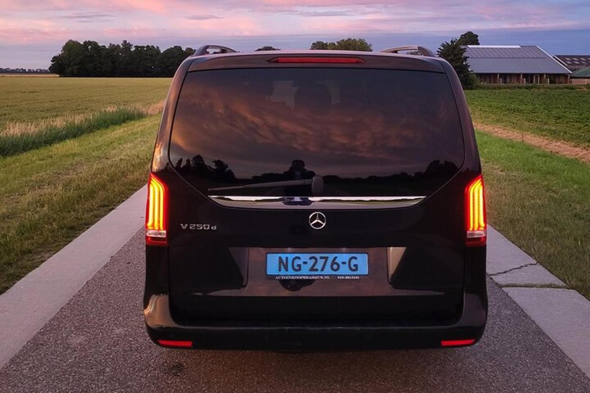 o mașină neagră este parcată pe un drum
