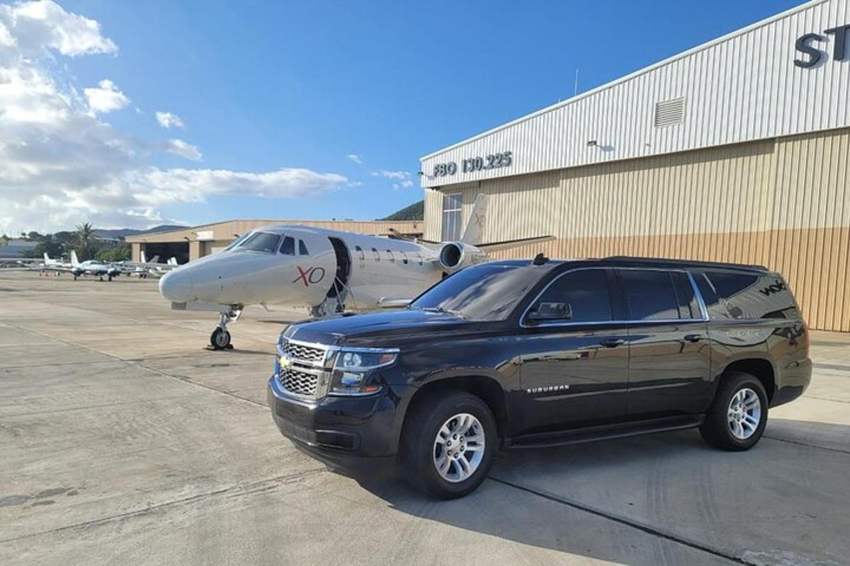 a black suv parked in front of an airplane