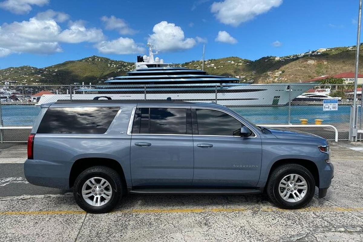 a silver suv parked in front of a cruise ship