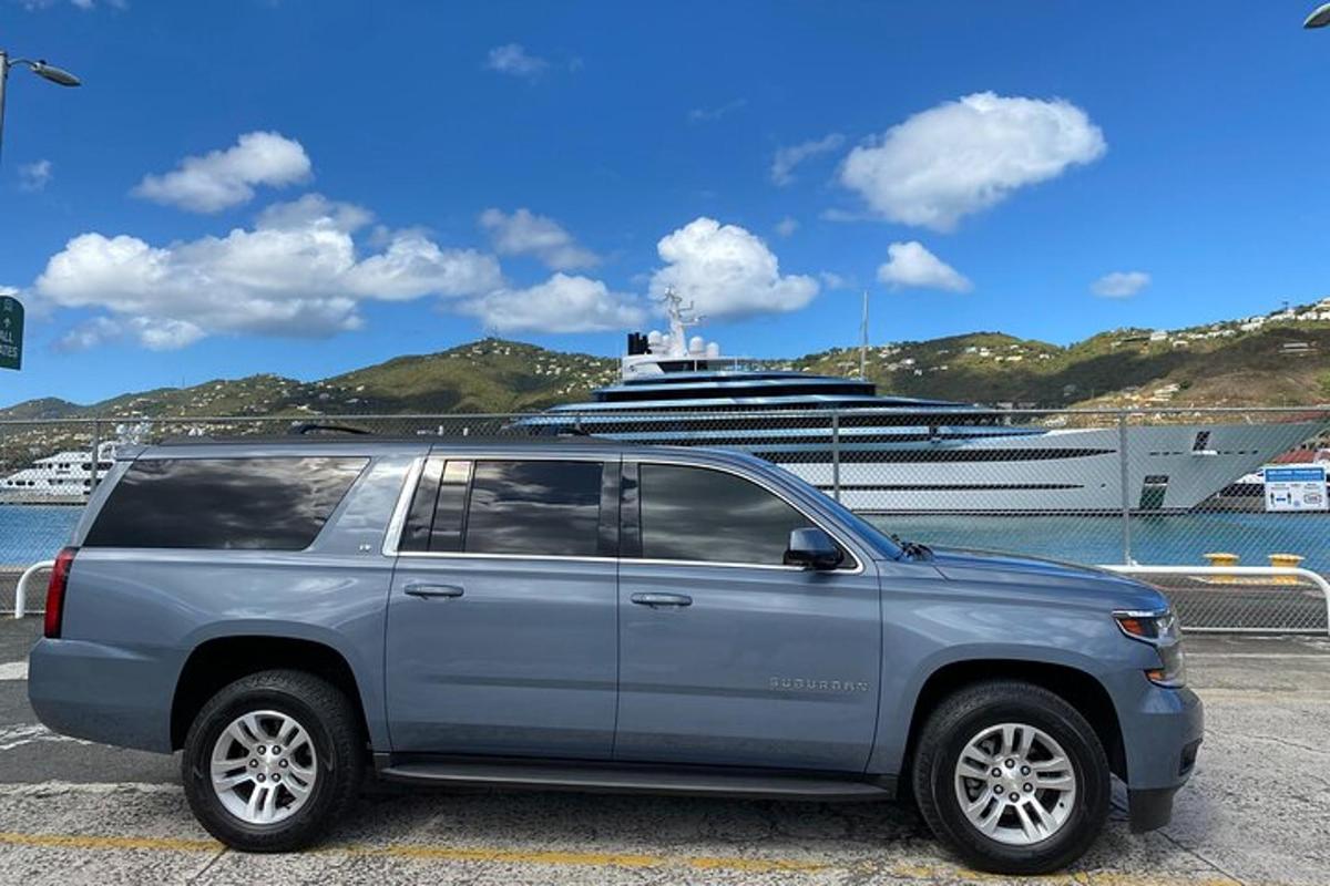 a silver suv parked in front of a cruise ship