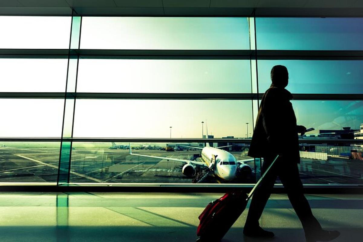 una persona che cammina in un aeroporto guardando un aereo