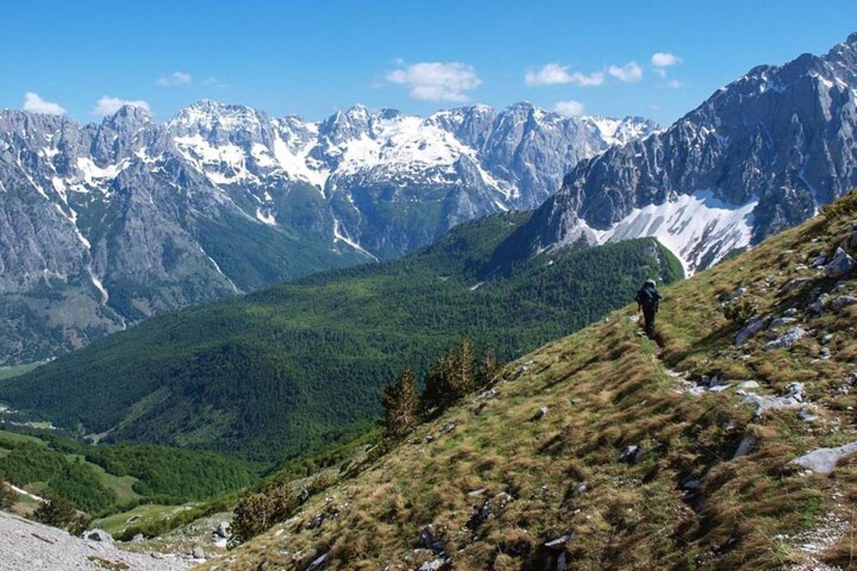 seseorang yang berjalan di atas gunung dengan gunung yang dilitupi salji