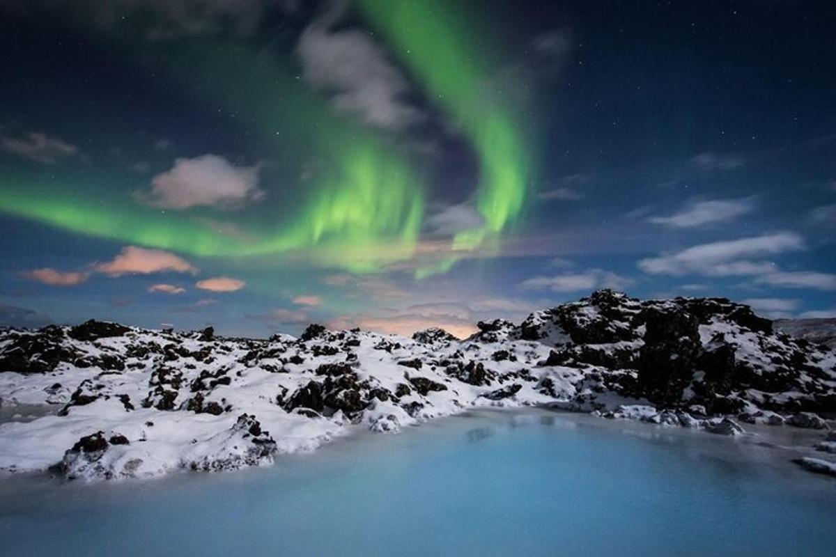 Una imagen de la aurora bailando en el cielo sobre un campo cubierto de nieve.