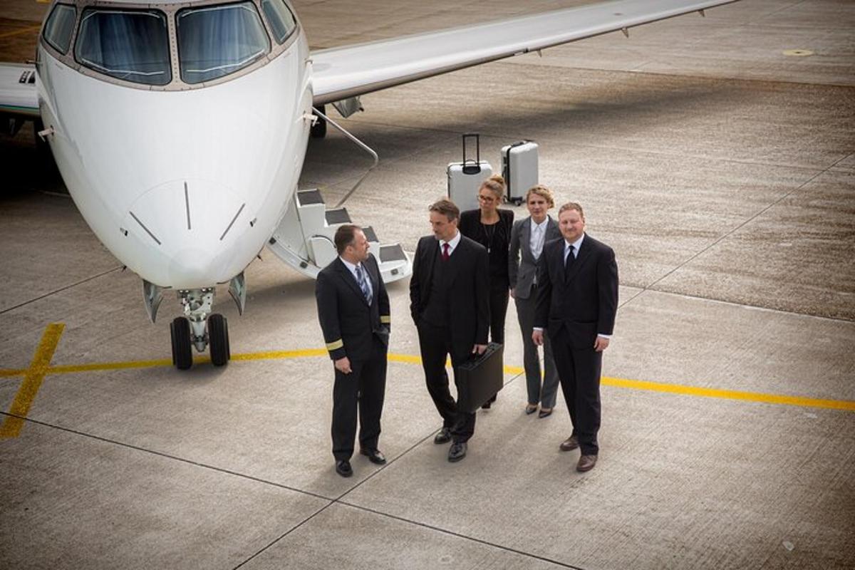 a group of men in suits standing next to an airplane