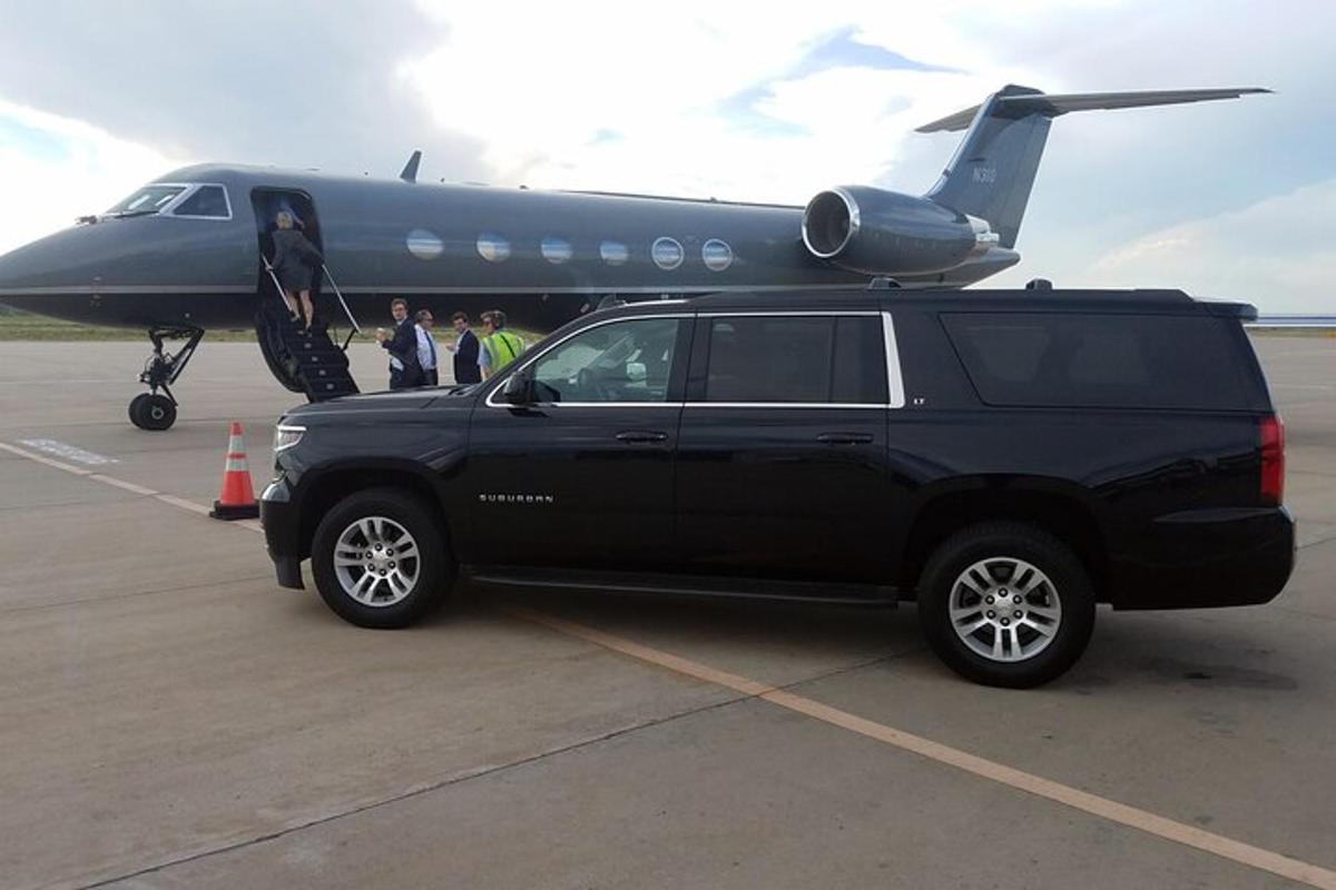 a black truck parked in front of an airplane