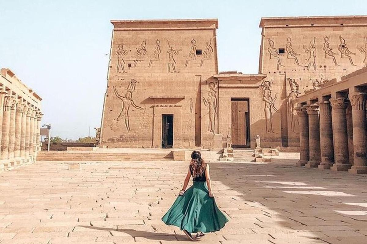 eine Frau in einem grünen Kleid steht vor einem Gebäude