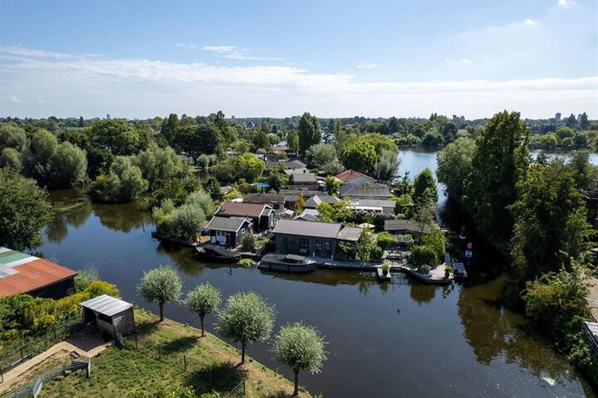 an aerial view of a river with houses and boats