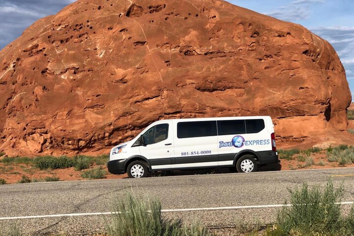 a van parked on the side of a road next to a rock