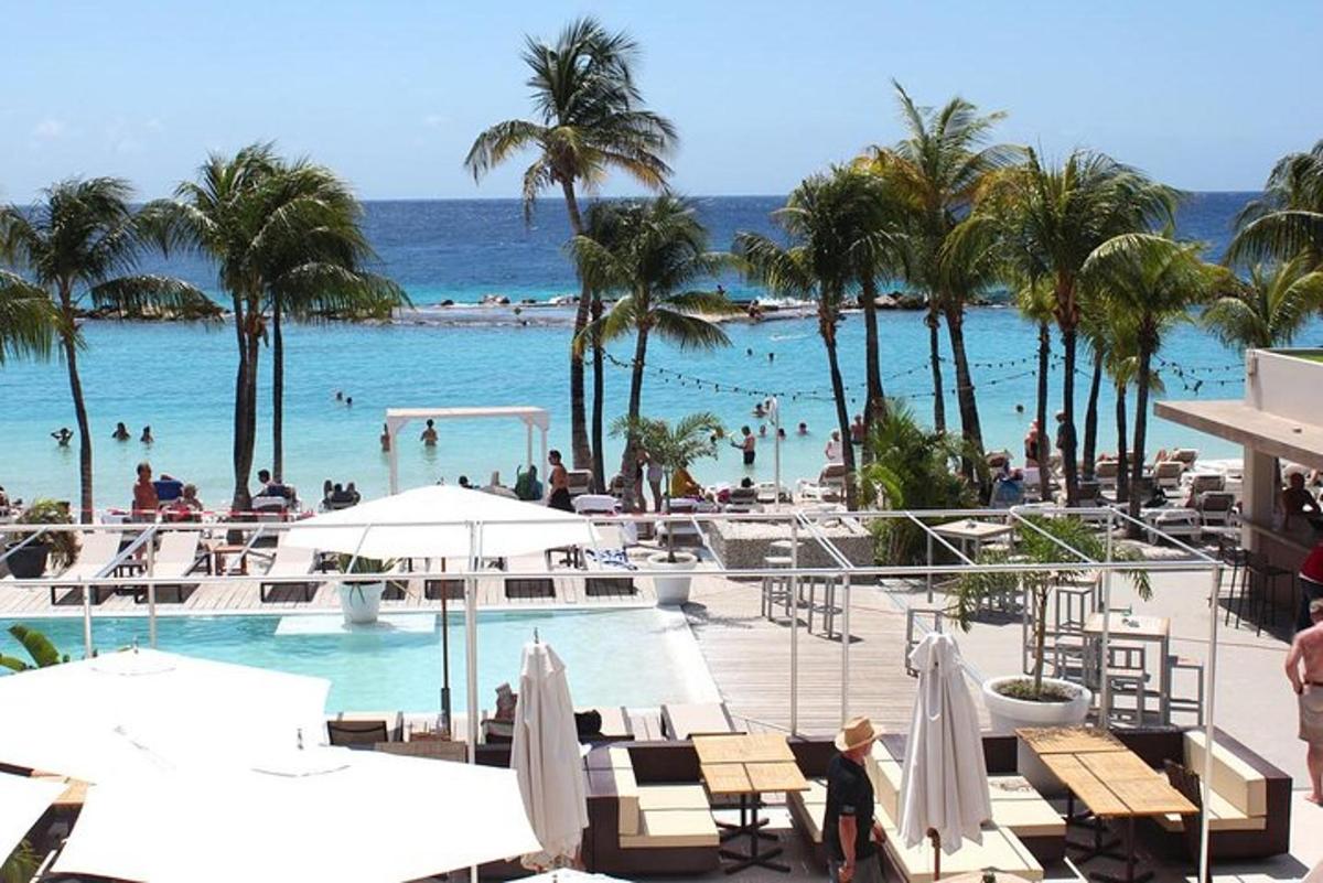 resort s bazénem a pláží s palmami