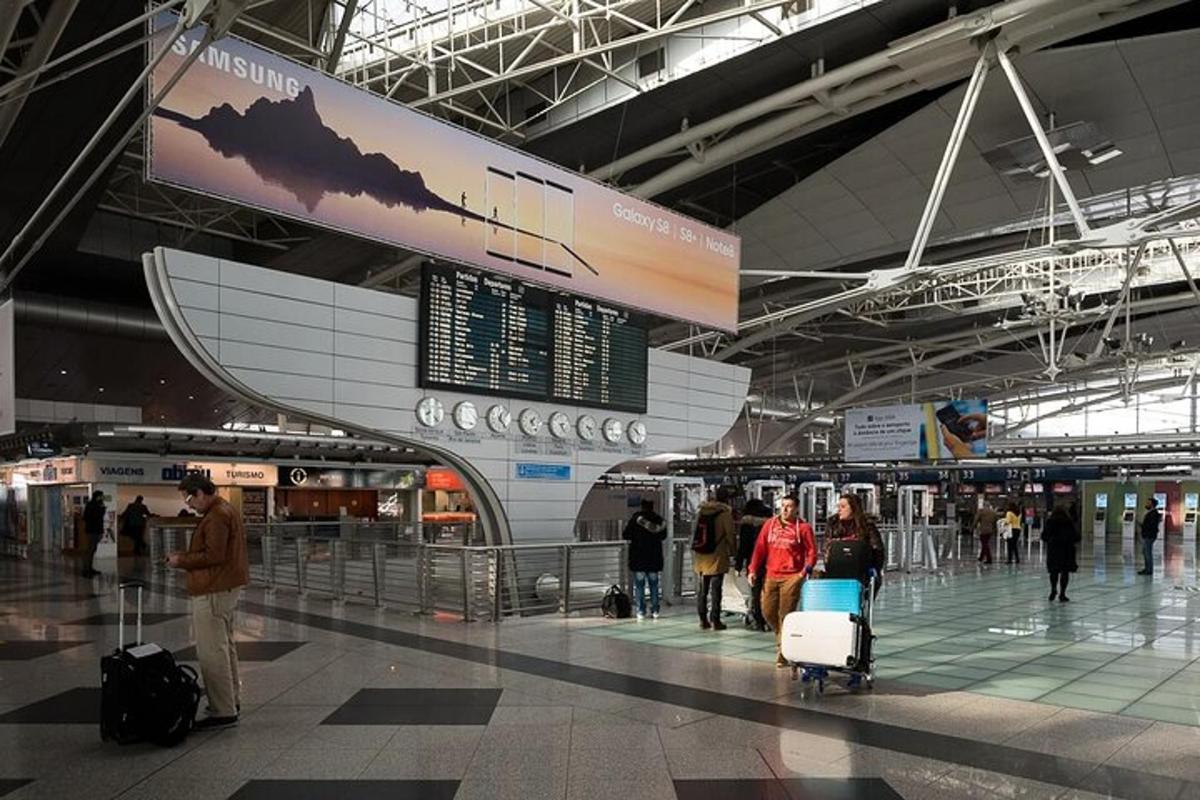 un gruppo di persone che camminano in un aeroporto con i bagagli