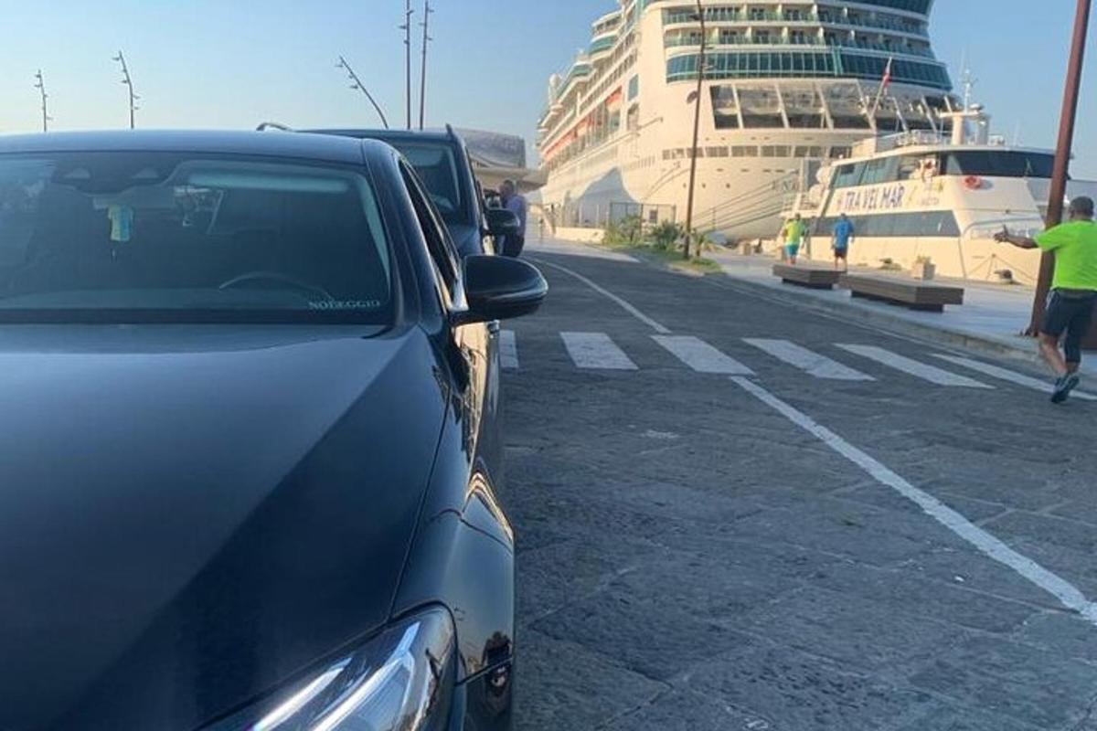 ein Auto, das auf einem Parkplatz neben einem Kreuzfahrtschiff geparkt ist