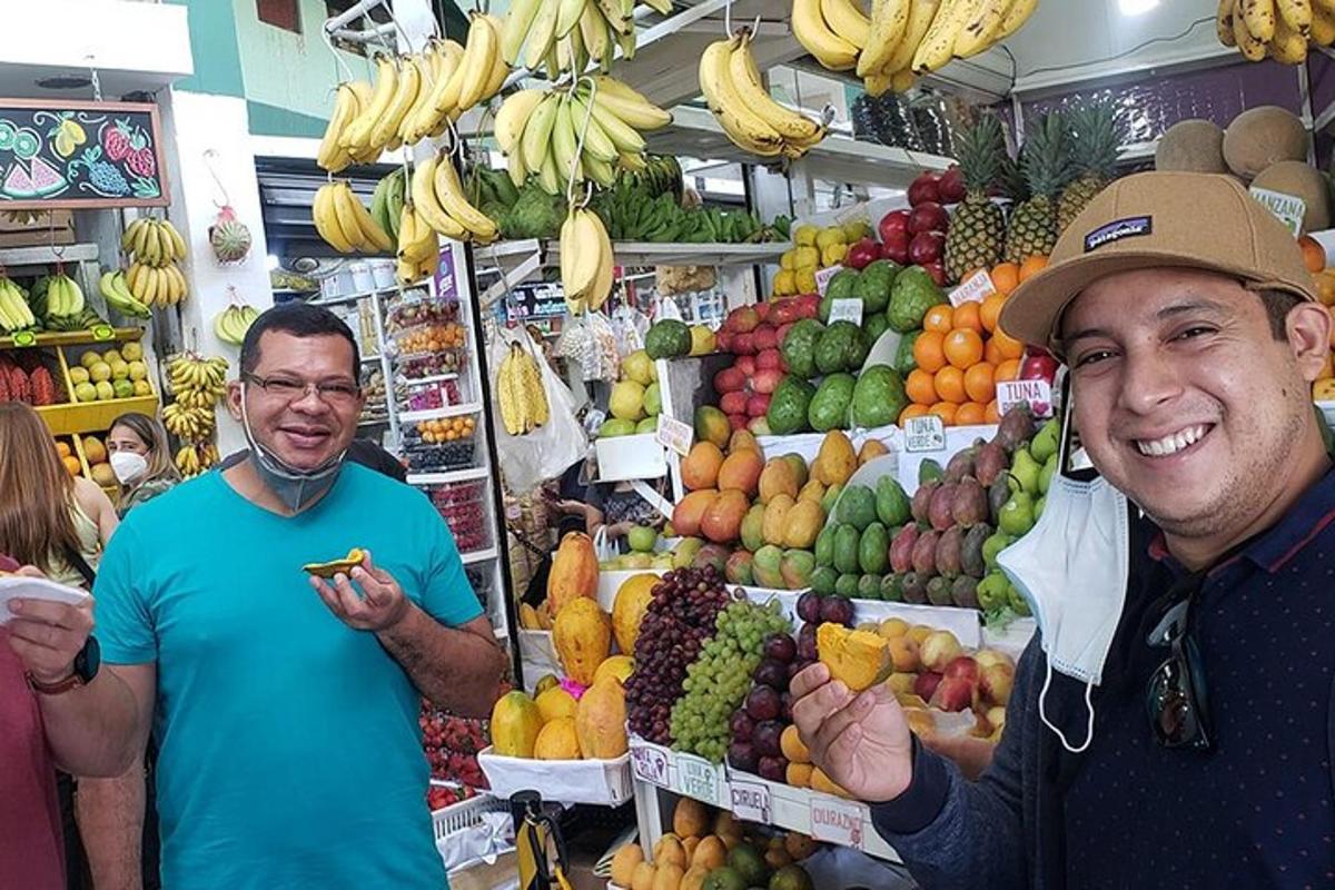 Dos hombres de pie en un mercado con frutas y verduras.