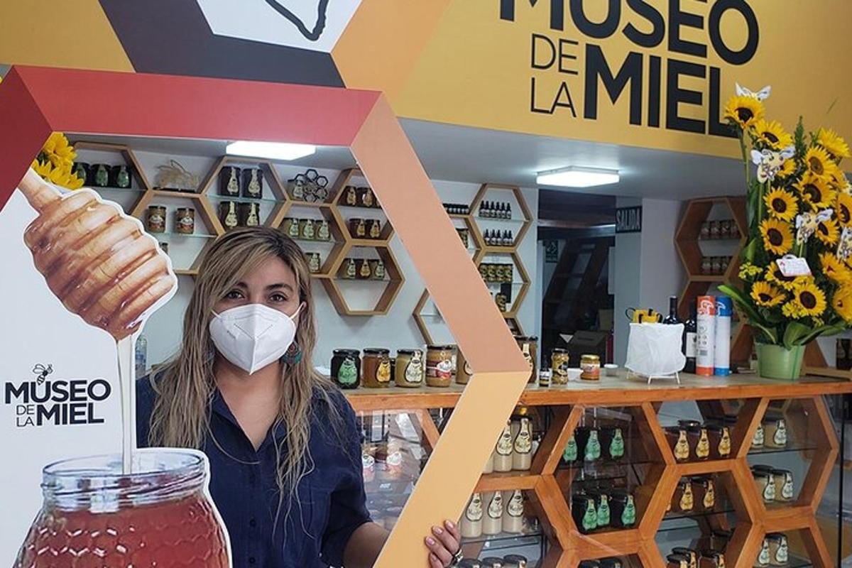 μια γυναίκα που φοράει μάσκα κρατώντας ένα βάζο λεμονάδας με άρωμα άλκης