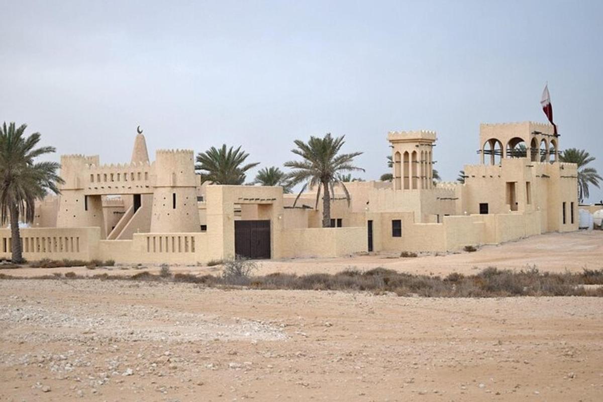 a building in the middle of a desert with palm trees