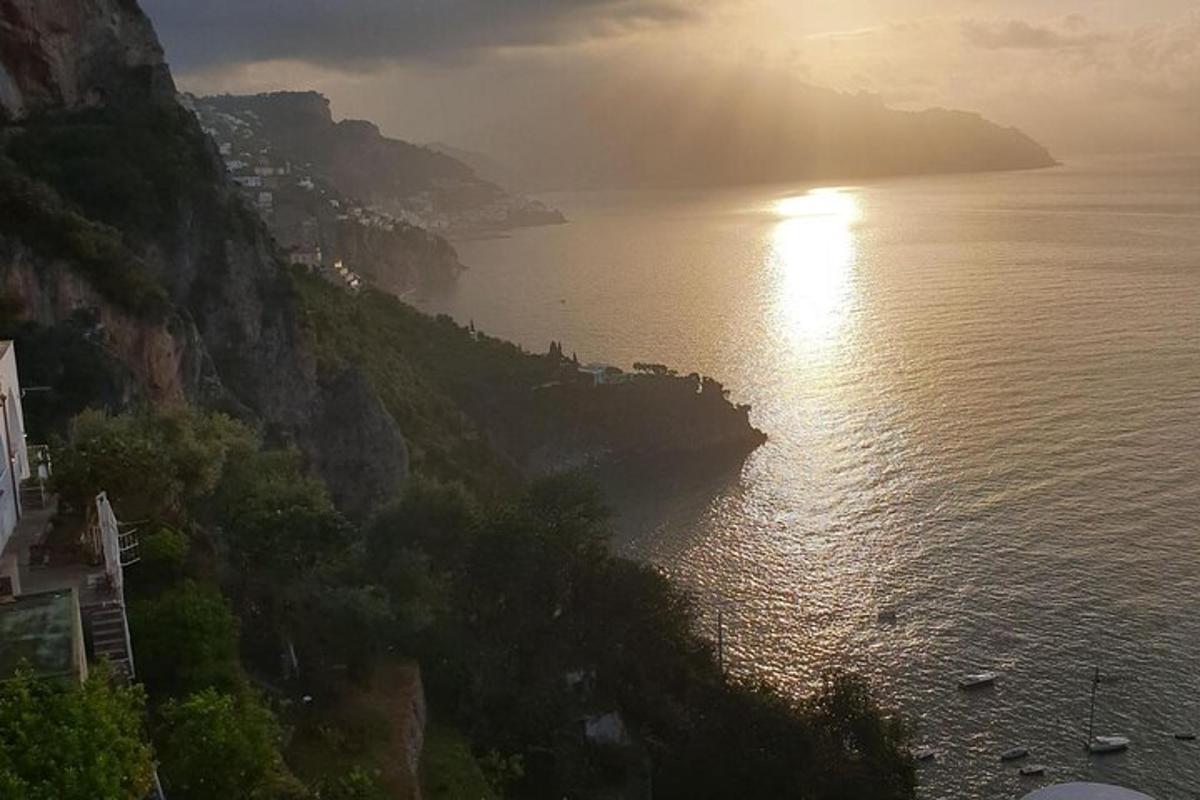 μια θέα στον ωκεανό με τον ήλιο σε ένα βουνό