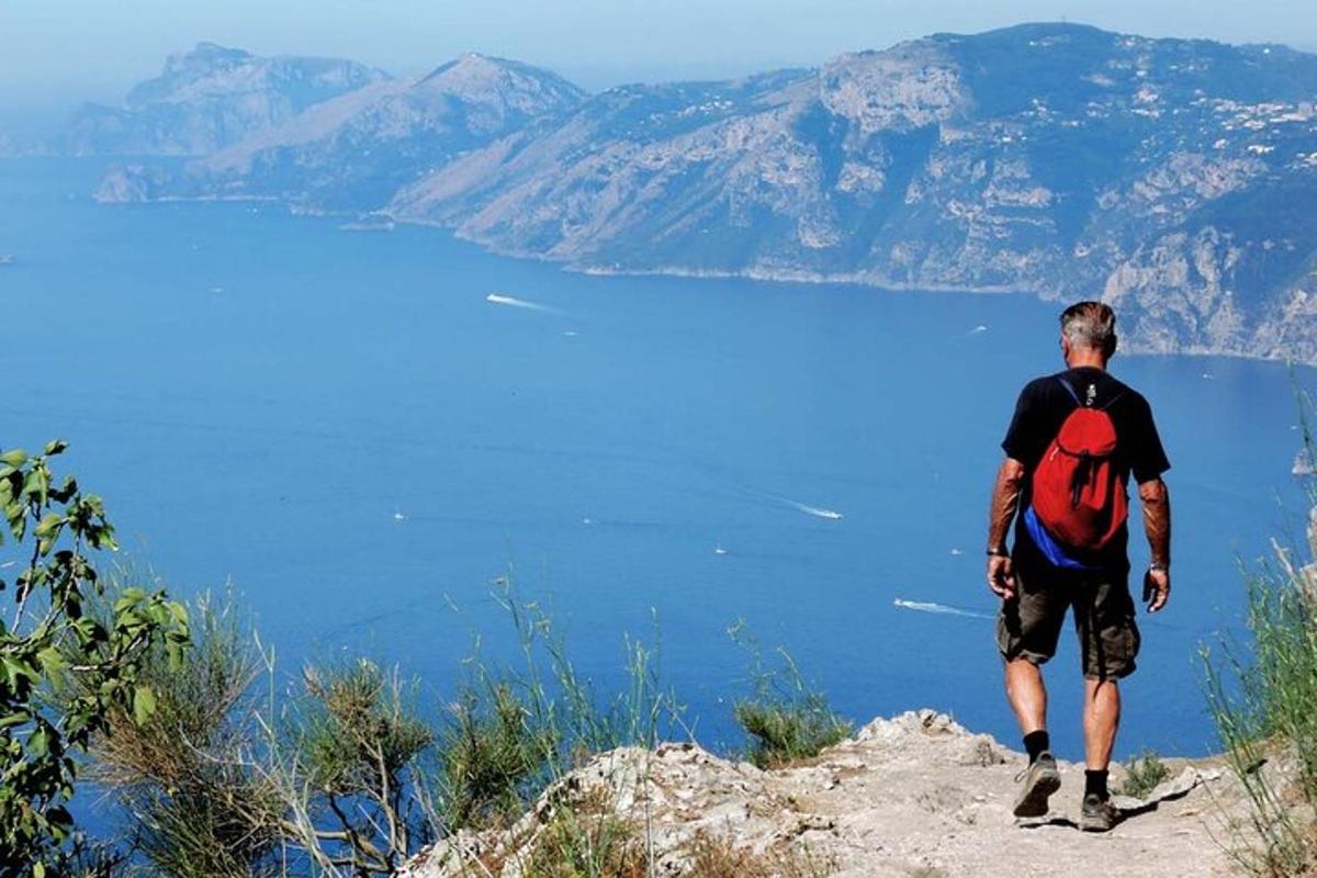 a man with a backpack standing on top of a mountain