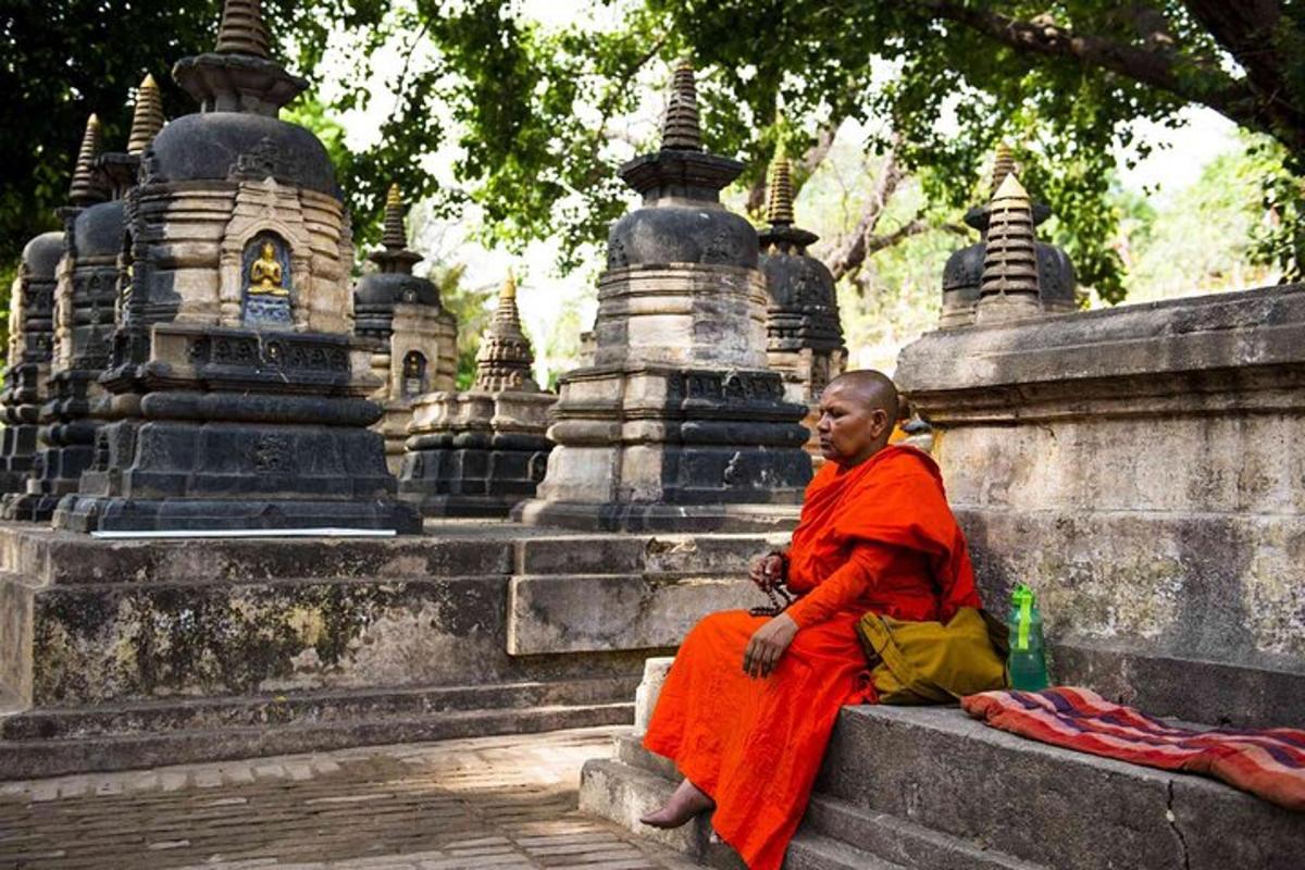 una donna seduta su un muro di fronte a un tempio