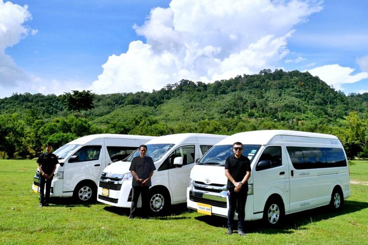 a group of three white vans parked in a field