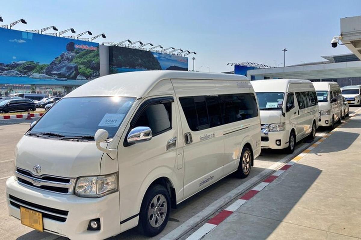 a row of white vans parked in a parking lot
