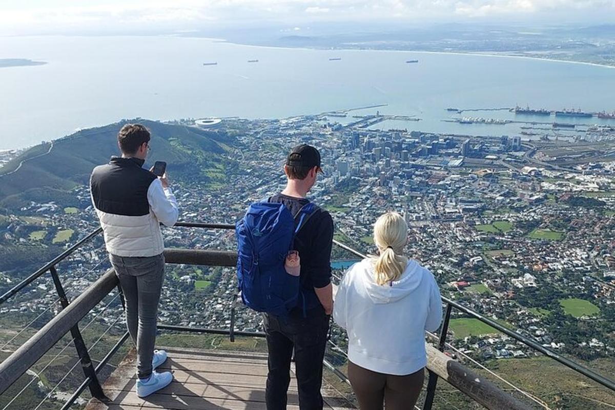 en grupp på tre personer som står på toppen av ett berg