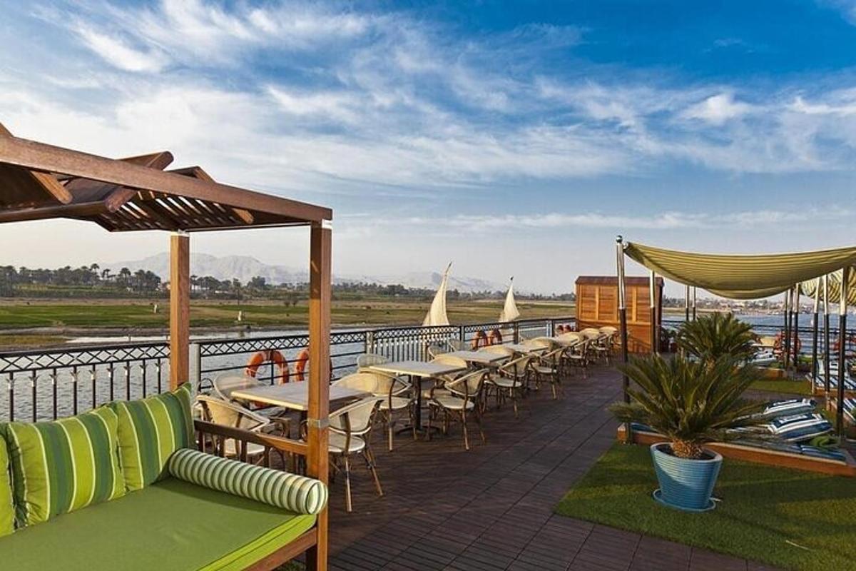 eine Terrasse mit Tischen und Stühlen und Blick auf das Wasser