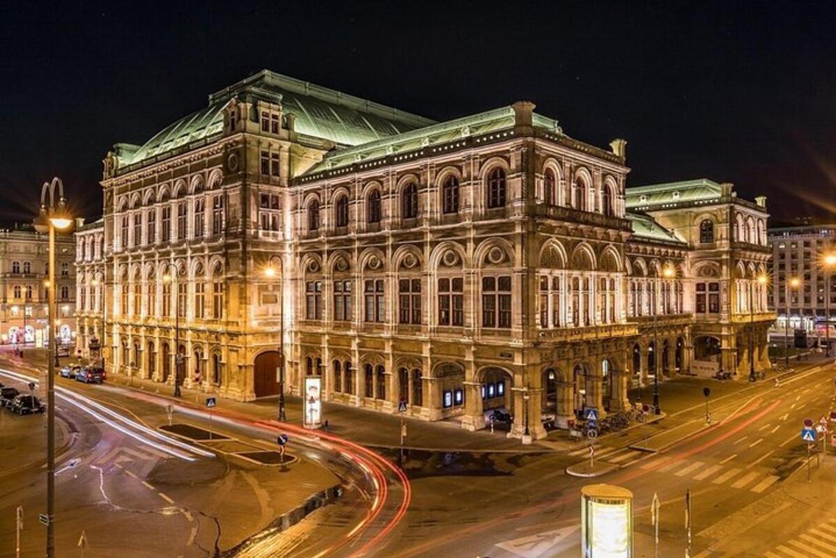 Un gran edificio con una calle enfrente por la noche.