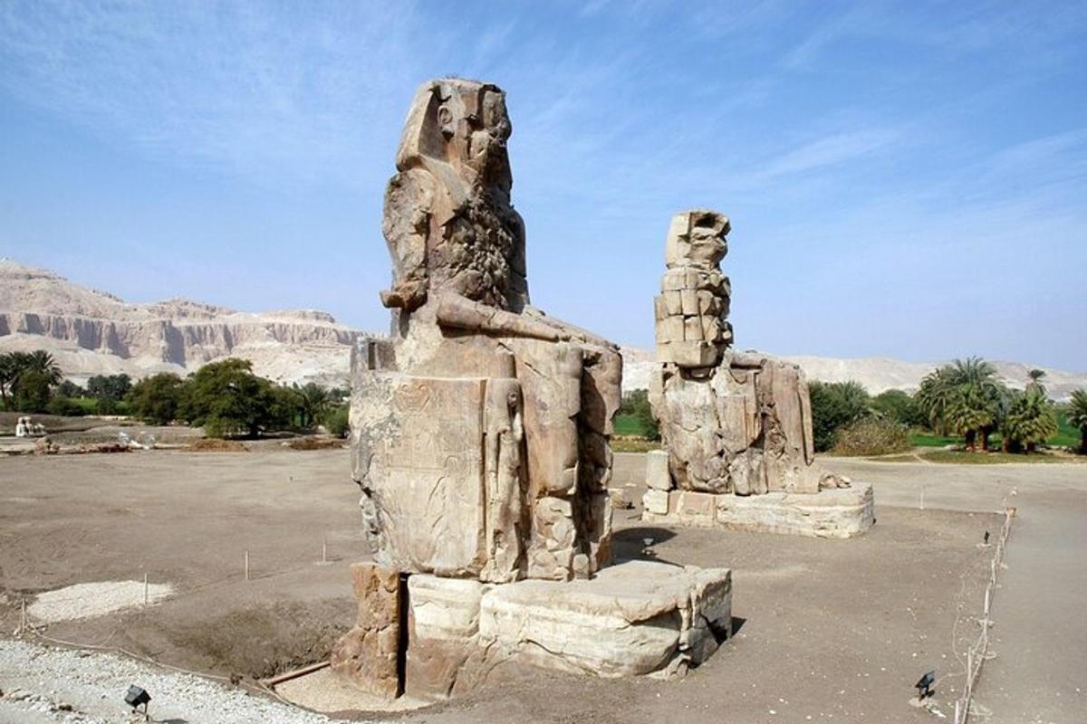 une statue dans un parking avec des montagnes en arrière-plan