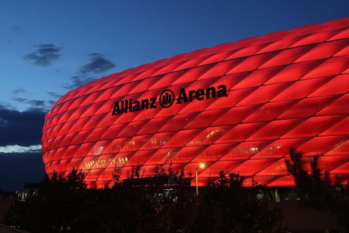 uma grande bola de futebol vermelha é iluminada à noite