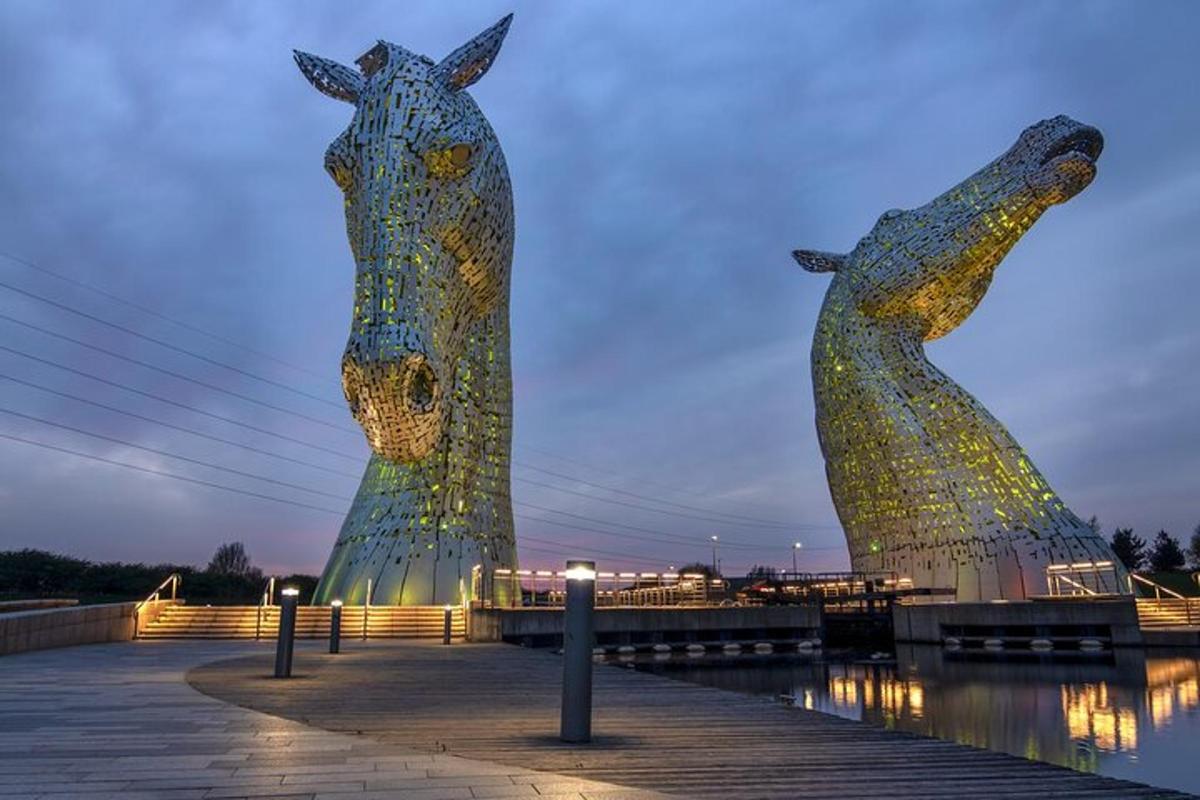two statues of horses are lit up at night
