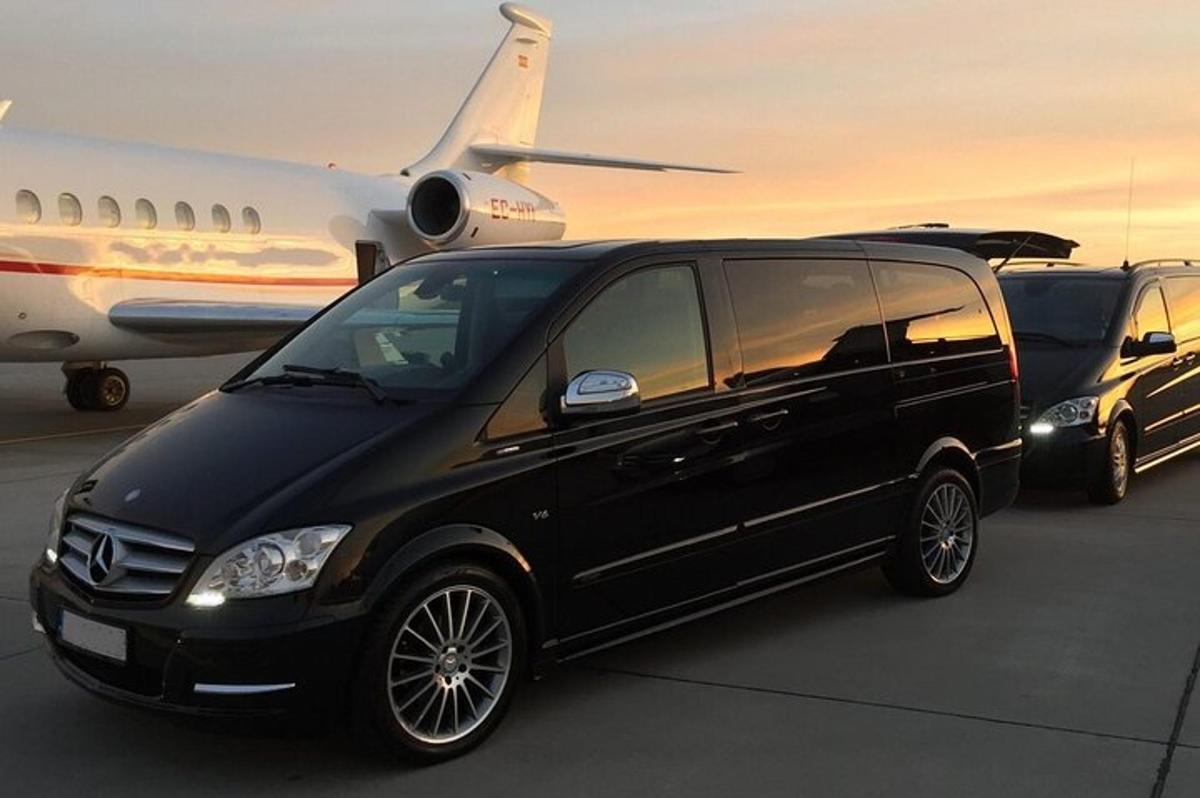 en svart limousin parkert ved siden av et fly