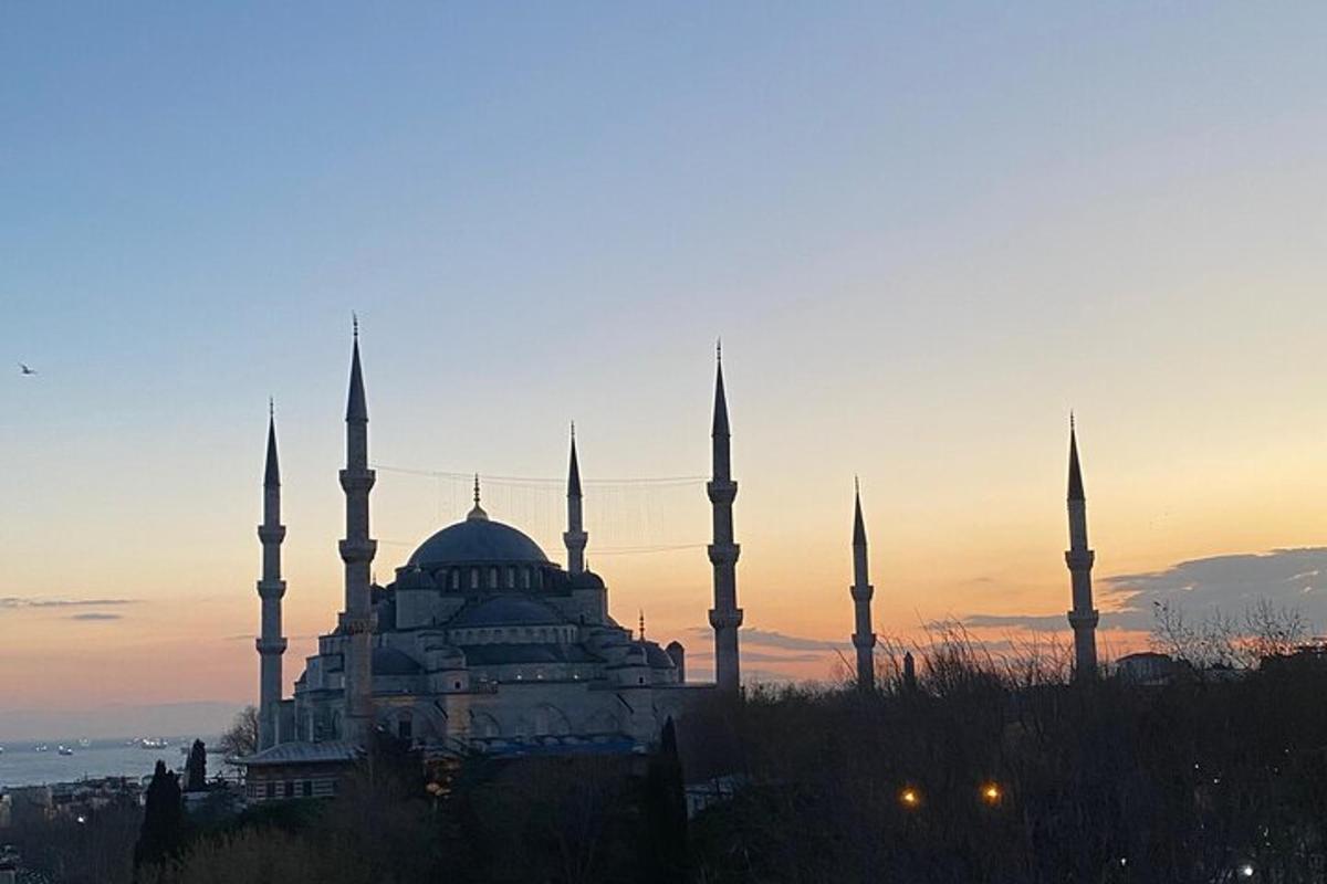 bygging með hvelfingum og minaretum fyrir framan sólsetur