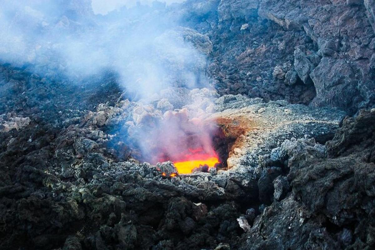 Una vista aérea de un volcán con humo y lava.