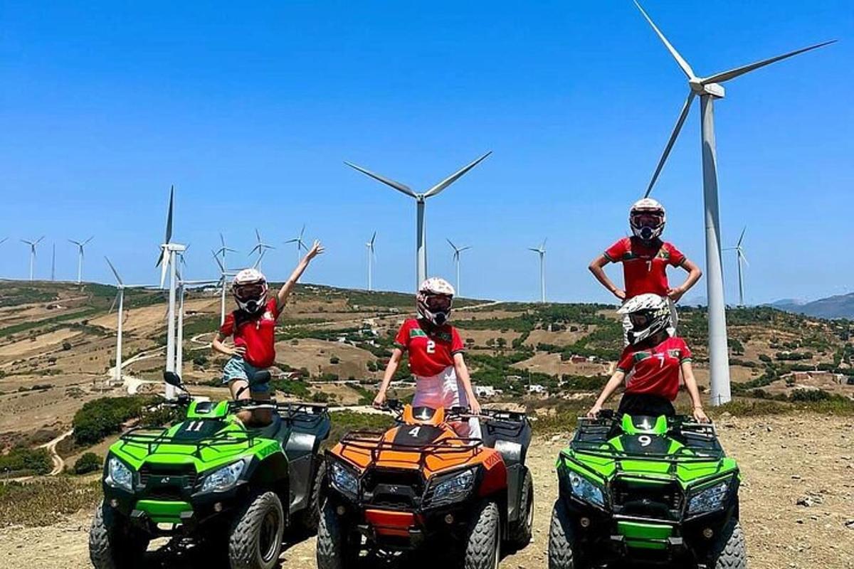 a group of people riding on atvs in front of wind turbines