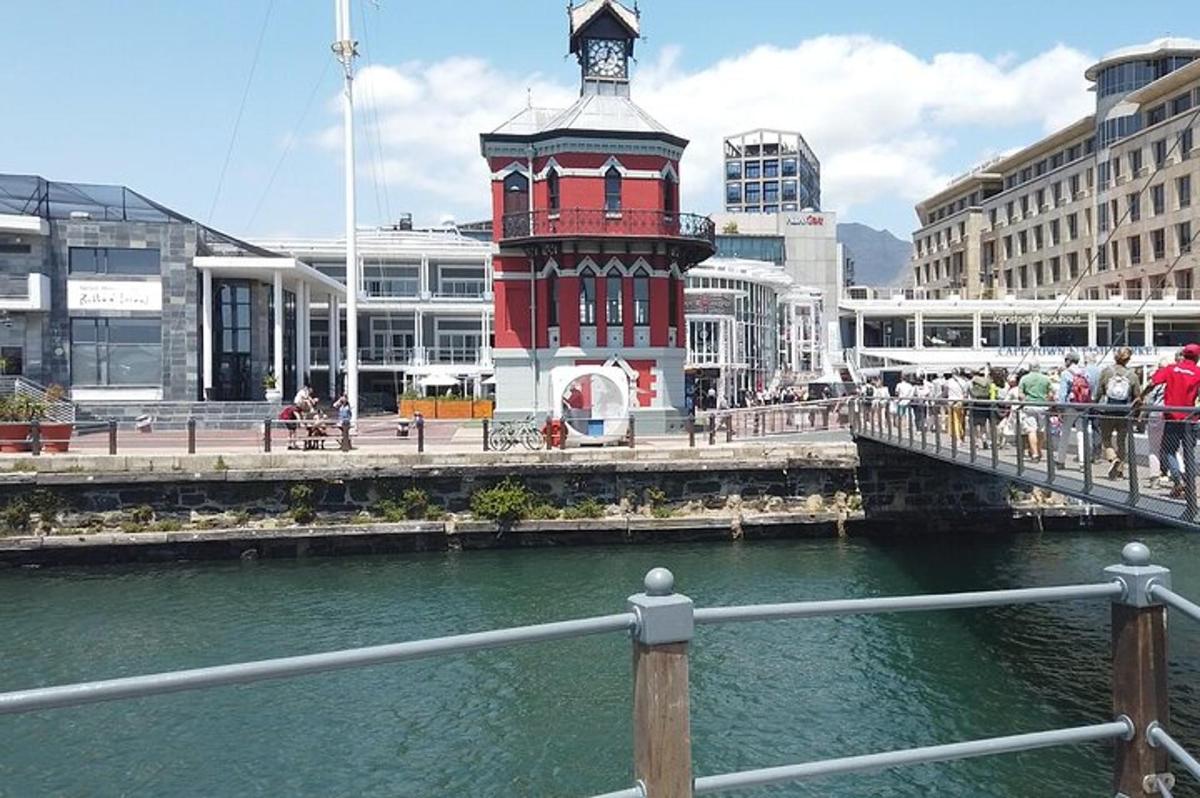 a red clock tower on a bridge over a river