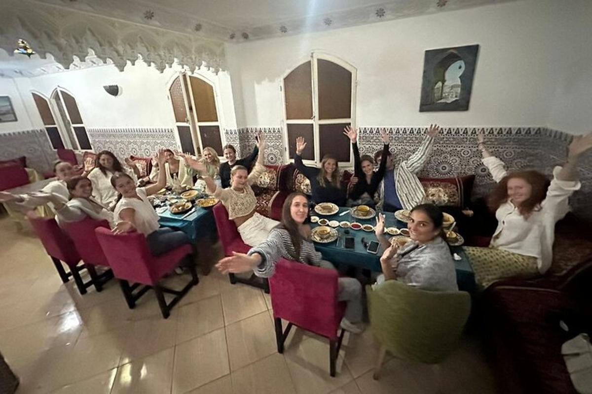 um grupo de pessoas sentadas à mesa com as mãos no ar