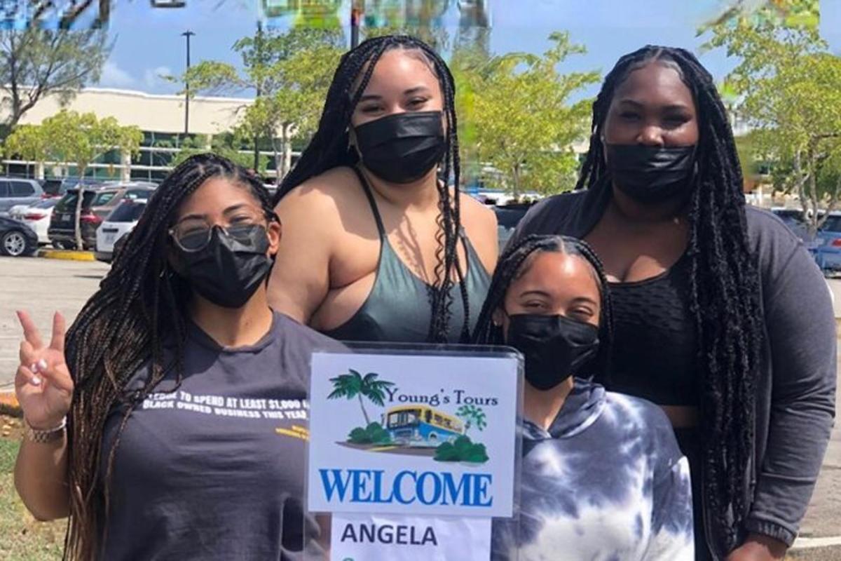 Un grupo de mujeres con máscaras sosteniendo un cartel.